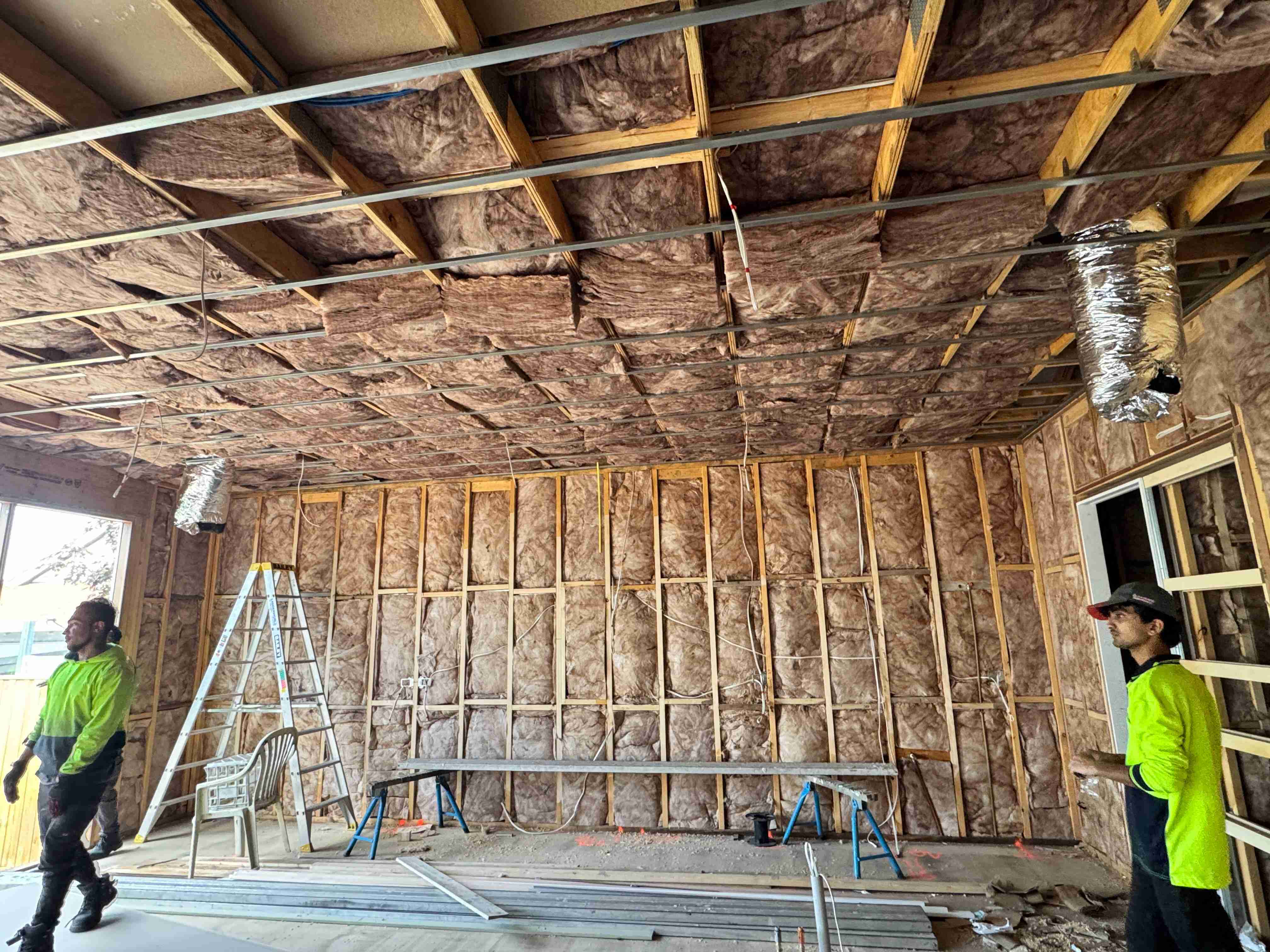 Tradesperson installing ceiling insulation in a home